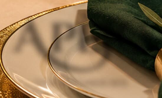 A gold-rimmed plate with a green napkin
